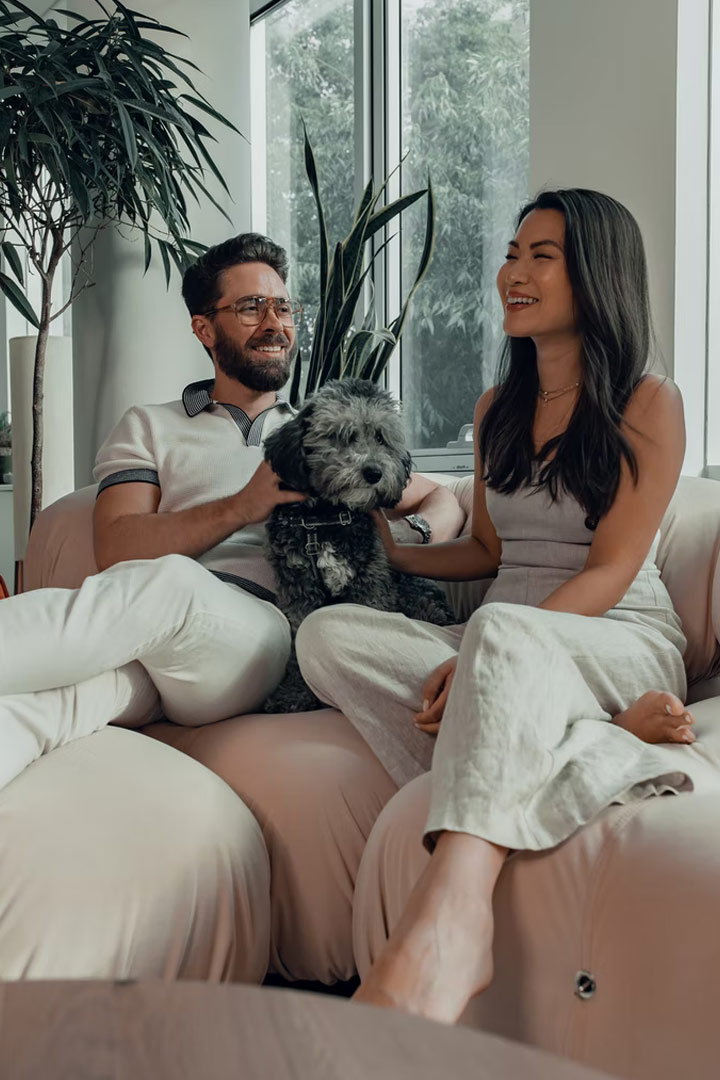 Couple sitting on couch with dog